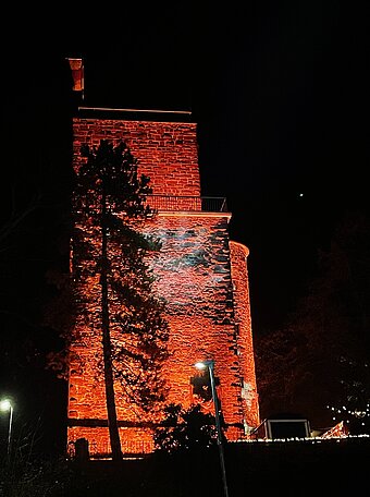 Orange beleuchteter Turmberg-Turm bei Nacht